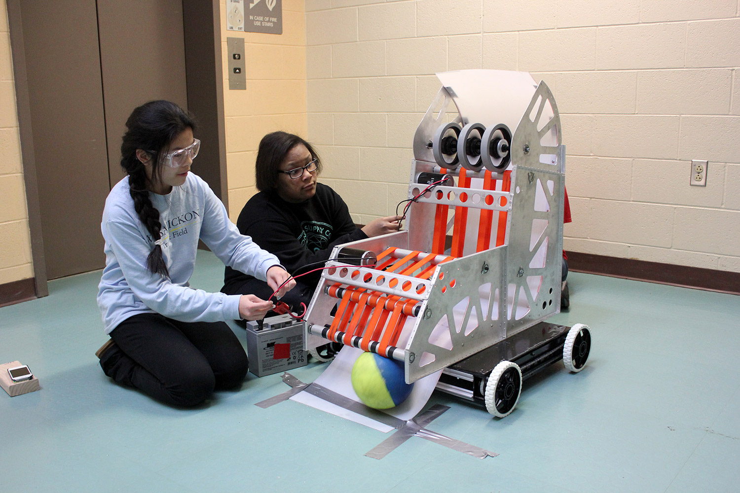 Students work to test the ball path on an almost complete machine.